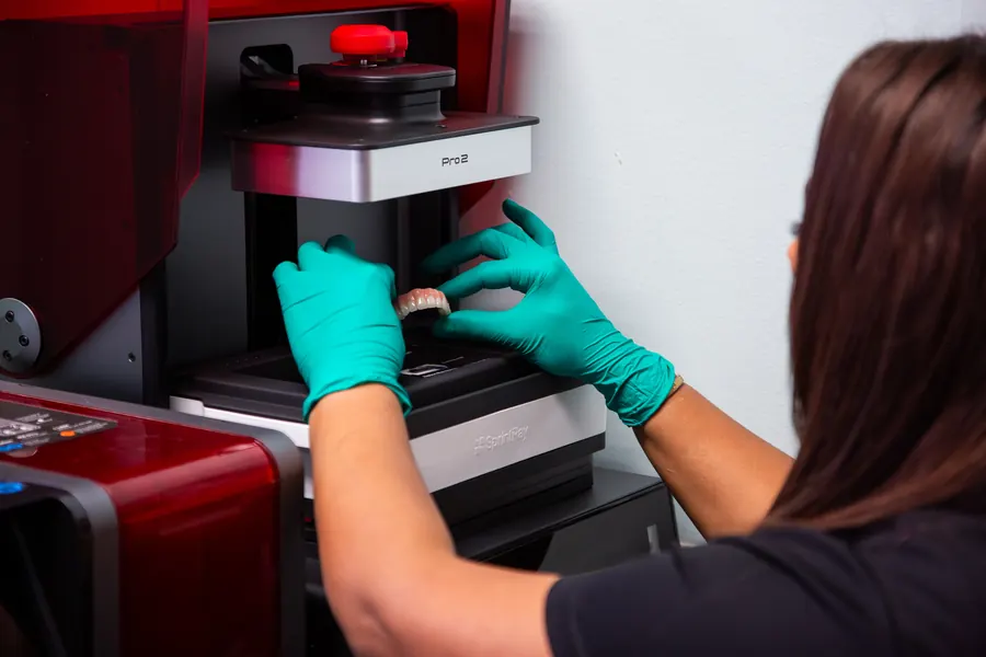 A lab technician operating the in-house 3D printing and milling equipment